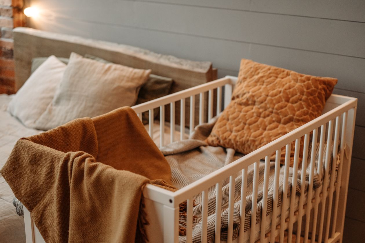 White crib with fitted sheet in a cozy nursery