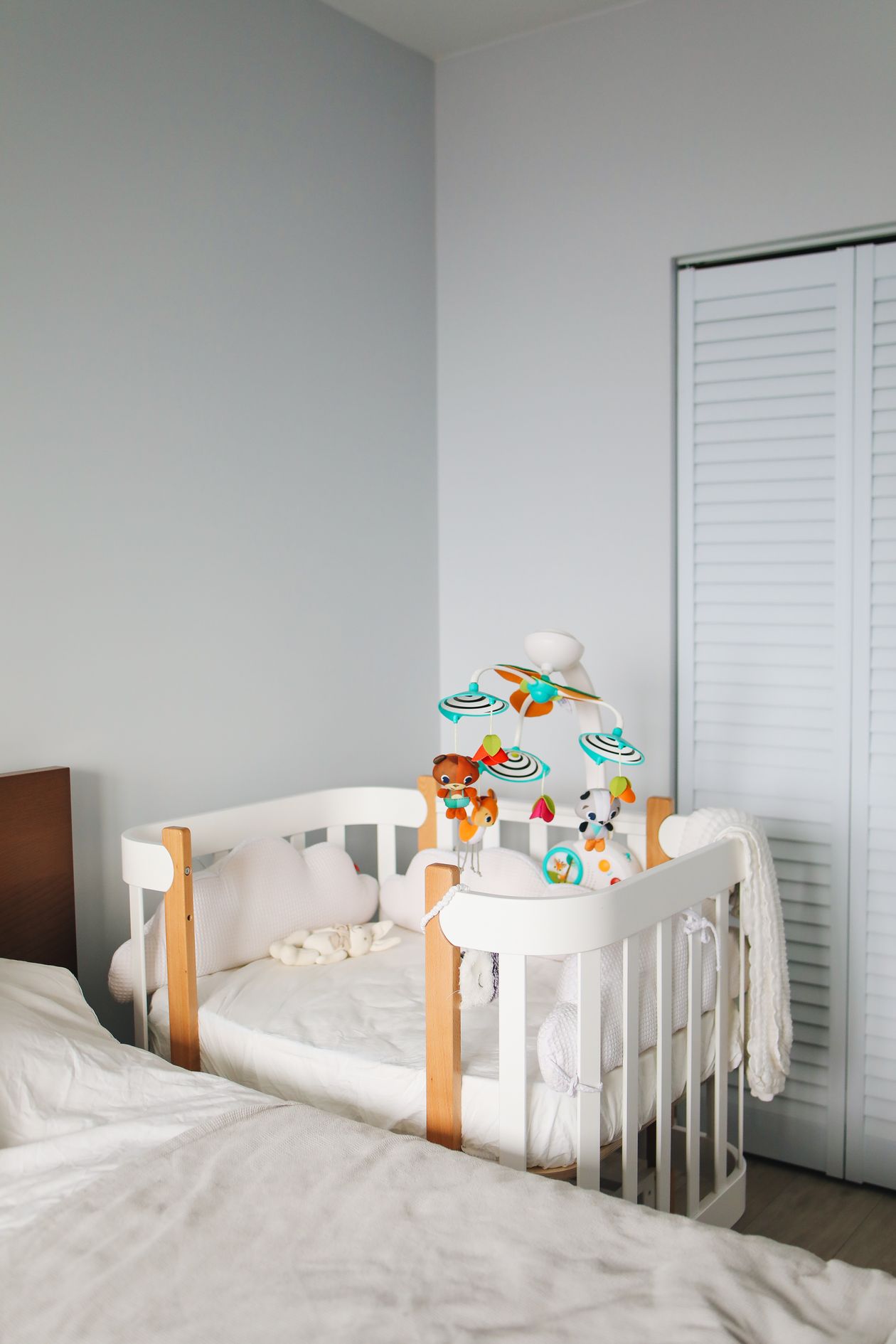 Light nursery with a wooden crib ready for bedtime