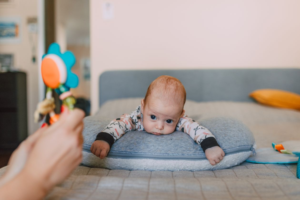 Baby looking at a colorful toy during floor play